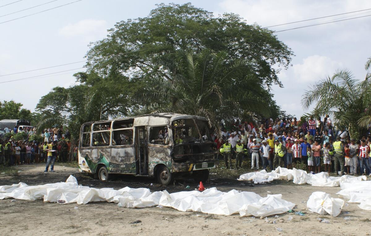 Bags containing children's remains are lined up near a charred bus in Fundacion, in northern Colombia, on Sunday.