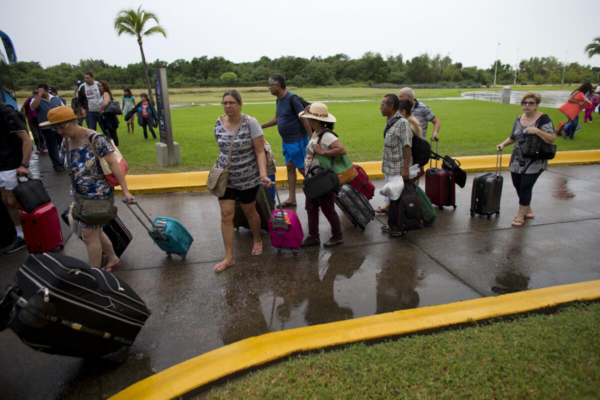 As Hurricane Patricia approaches, tourists in Puerto Vallarta, Mexico, wait to board buses that will take them to a shelter on Oct. 23, 2015. Hundreds of flights have been canceled and a cruise ship from Los Angeles has been recalled because of the storm.
