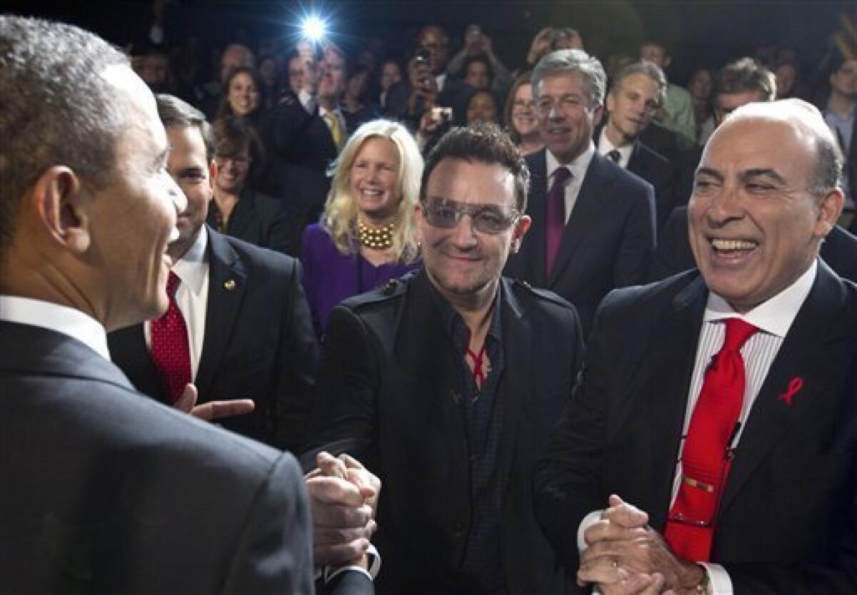 FILE - This is a Thursday, Dec. 1, 2011 file photo of President Barack Obama as he greets U2 front man Bono, center, and Muhtar Kent the chairman of the Board and chief executive officer of The Coca-Cola Company, right, after speaking during a World AIDS Day event at George Washington University in Washington. (AP Photo/Carolyn Kaster, File)