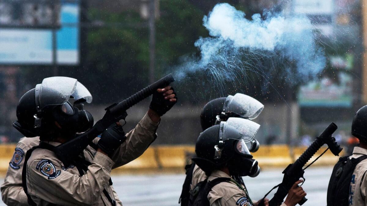 Venezuelan National Guard personnel in riot gear crack down on a march of opposition activists protesting against President Nicolas Maduro's government, in Caracas on April 13.
