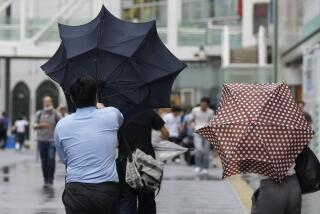 A man with an umbrella struggles against strong wind brought by Typhoon Ampil, while walking on a street, in Tokyo, Japan, Friday, Aug. 16, 2024. (AP Photo/Hiro Komae)