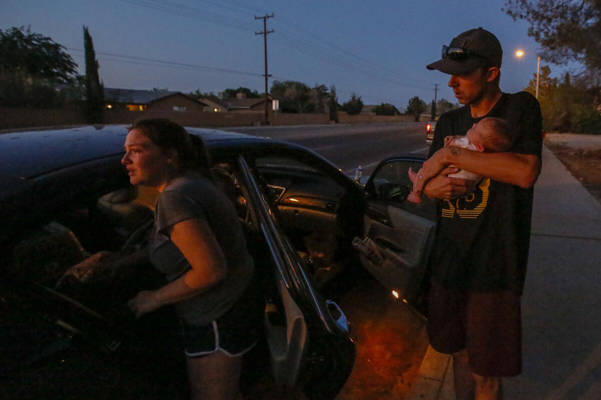 In Ridgecrest, Davia Speed and Peyton Speed, holding 1-month-old Lillian, get into their car after Friday night's 7.1 earthquake. (Irfan Khan/ Los Angeles Times)