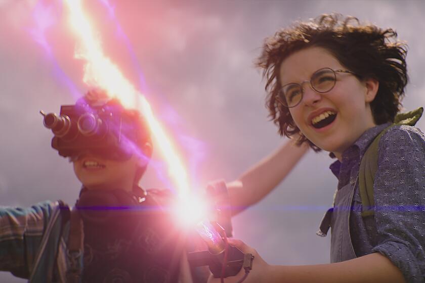 A boy wearing goggles, left, and a girl shooting pink lightning out of a gun