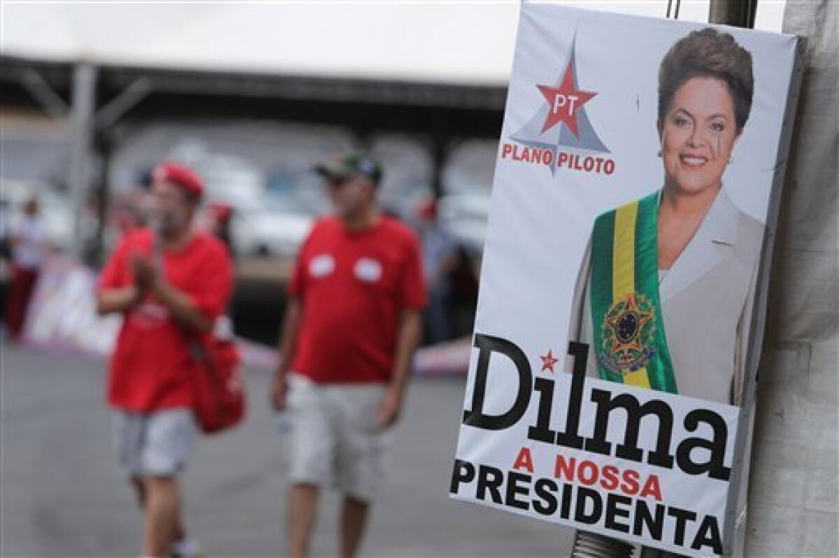 Gente pasa frente a una foto oficial de la presidenta brasileña suspendida Dilma Rousseff en Brasilia, 28 de agosto de 2016. Dilma enfrenta al Senado el lunes 29 de agosto de 2016, al entrar el juicio político en sus atepas finales.