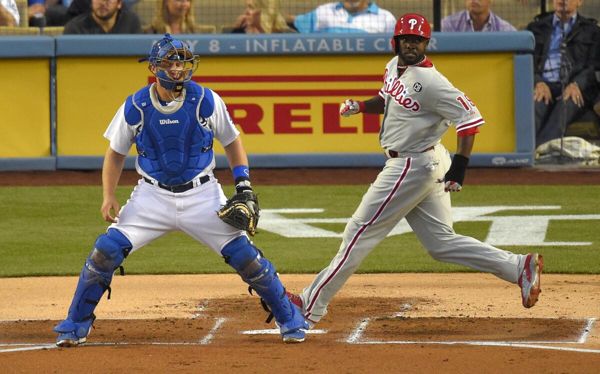 Philadelphia Phillies center fielder Tony Gwynn Jr., right, scores next to Dodgers catcher Tim Federowicz on a double by Carlos Ruiz in the first inning of the Dodgers' 7-0 loss Monday at Dodger Stadium.