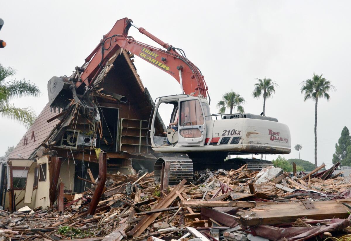 An excavator demolishes the iconic A-Frame building at 333 E. 17th St. in Costa Mesa.
