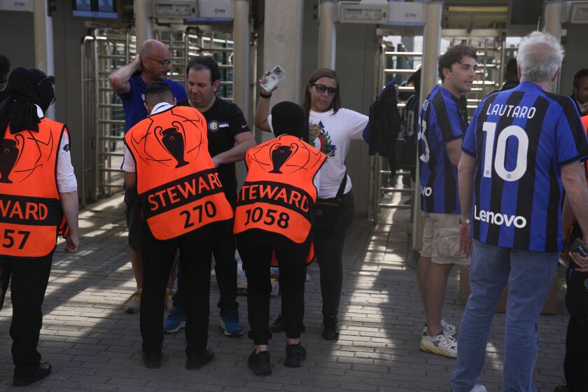 Spectators go through the security check as they enter the stadium ahead of the Champions League final soccer match between Manchester City and Inter Milan at the Ataturk Olympic Stadium in Istanbul, Turkey, Saturday, June 10, 2023. (AP Photo/Thanassis Stavrakis)