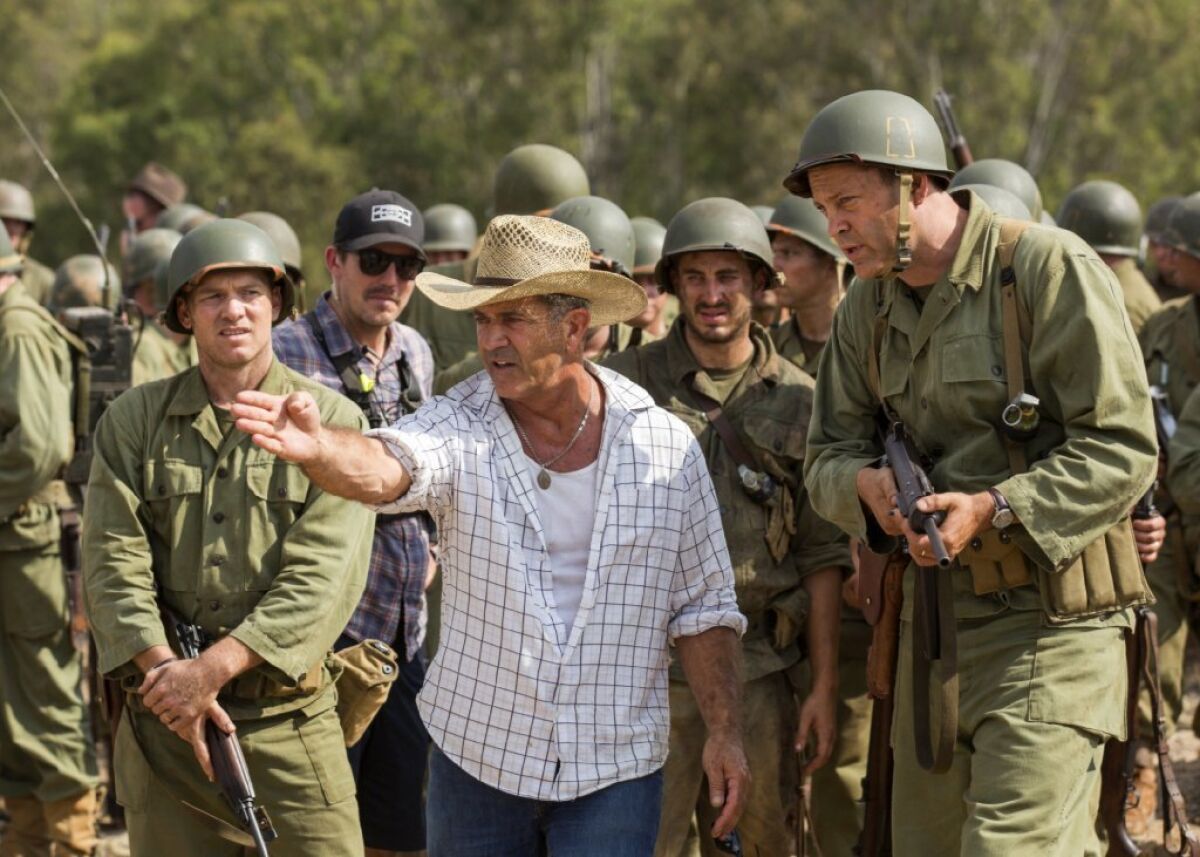 Director Mel Gibson, center, and actor Vince Vaughn, right, on the set of "Hacksaw Ridge."