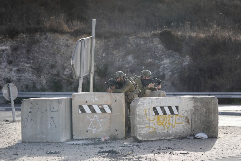 Israeli soldiers take position at a roadblock near the West Bank town of Nablus, Saturday, Sept. 24 2022. Israeli troops on Saturday shot and killed a Palestinian motorist who allegedly tried to ram his car into a group of soldiers patrolling in the occupied West Bank, according to Israeli soldiers and media. (AP Photo/Majdi Mohammed)
