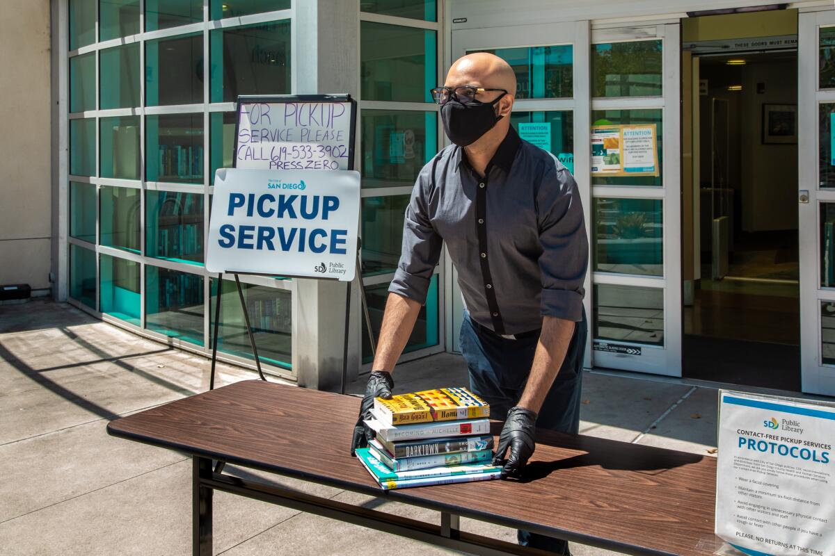 Librarian Bijan Nowroozian left books on a table outside a library branch in San Diego for patrons to pick up
