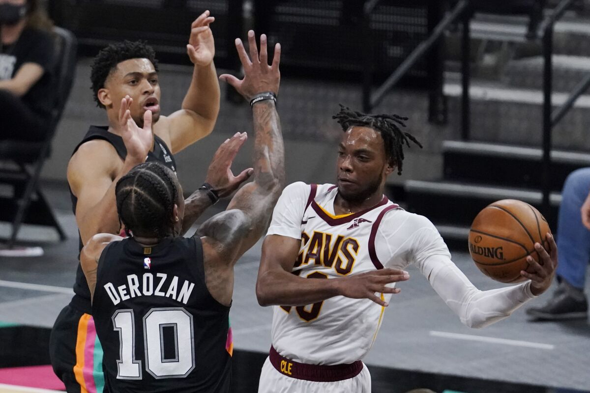 Cleveland Cavaliers guard Darius Garland, right, drives to the basket against San Antonio Spurs forward DeMar DeRozan (10) during the second half of an NBA basketball game in San Antonio, Monday, April 5, 2021. (AP Photo/Eric Gay)