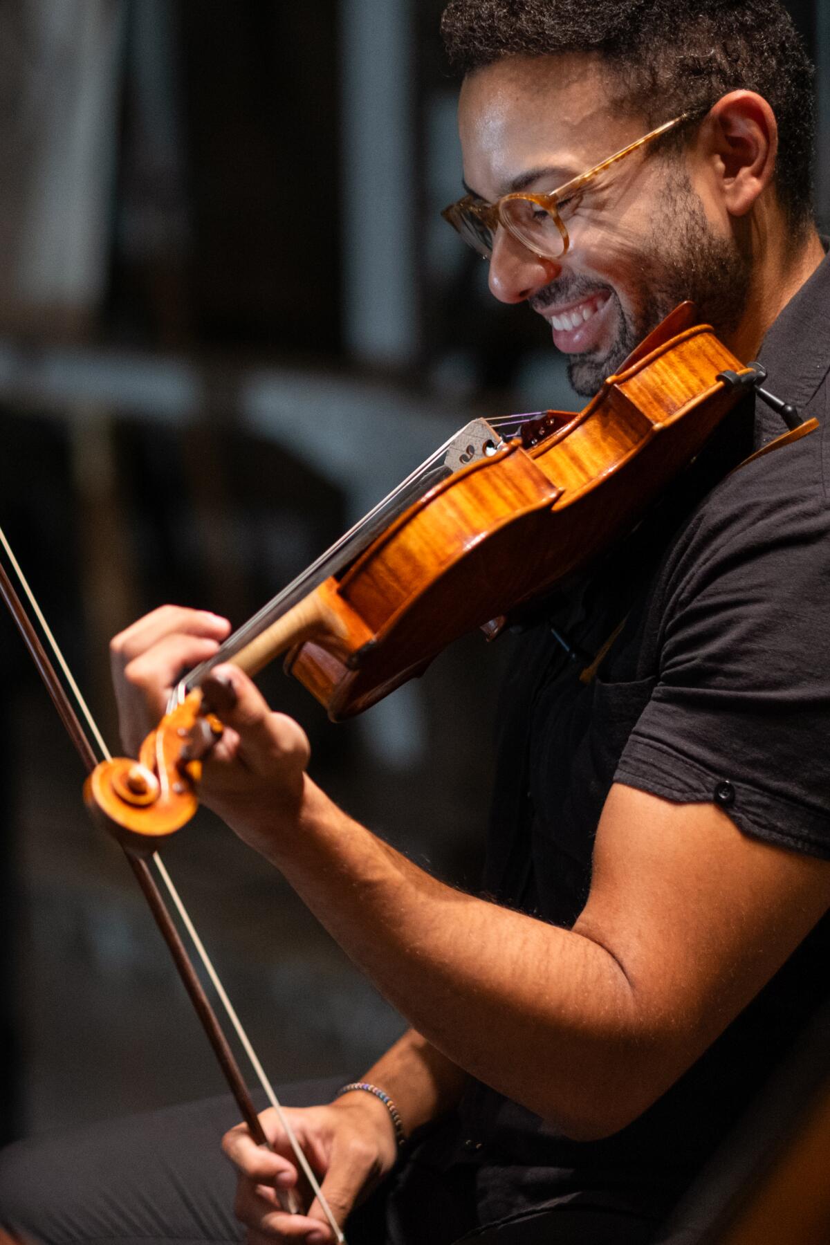 Violinist Kyle Gilner grins while performing with the Zelter String Quartet.