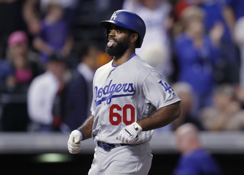 Dodgers outfielder Andrew Toles sticks out his tongue as he heads to home plate after hitting a go-ahead grand slam in the ninth inning off Rockies relief pitcher Adam Ottavino.