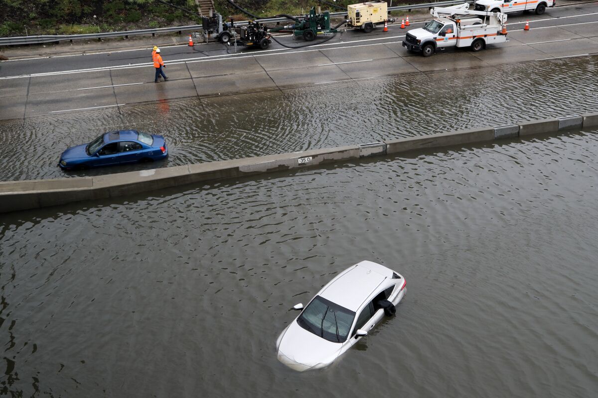 Cars sit half submerged in water on the freeway