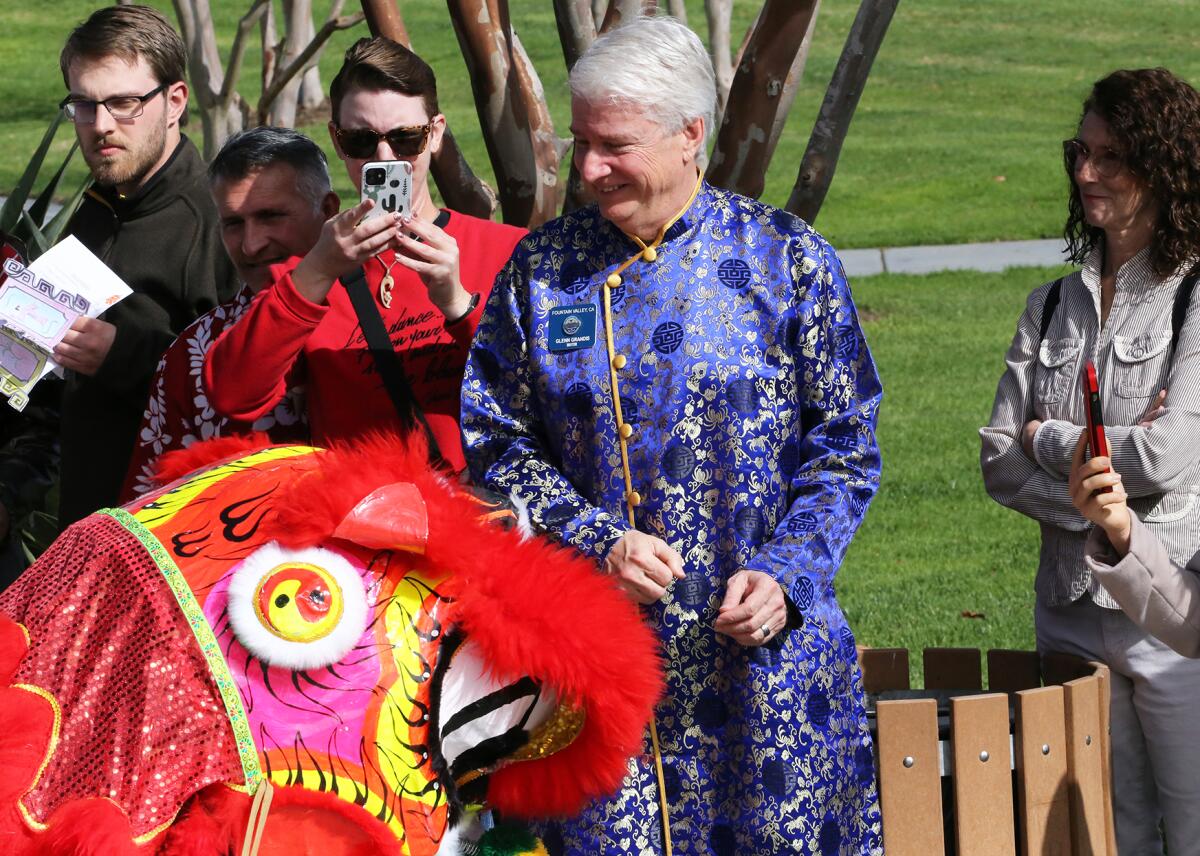 Fountain Valley Mayor Glenn Grandis, center, watches a lion dance at a Lunar New Year Festival on Saturday.