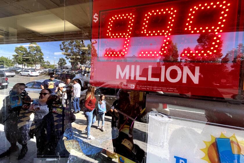 HAWTHORNE, CA - NOVEMBER 4, 2022 - - People, reflected, wait in line to buy tickets for Saturday's Powerball drawing at Bluebird Liquor in Hawthorne on November 4, 2022. Powerball's jackpot is $1.6 billion, the largest lottery prize ever. (Genaro Molina / Los Angeles Times)