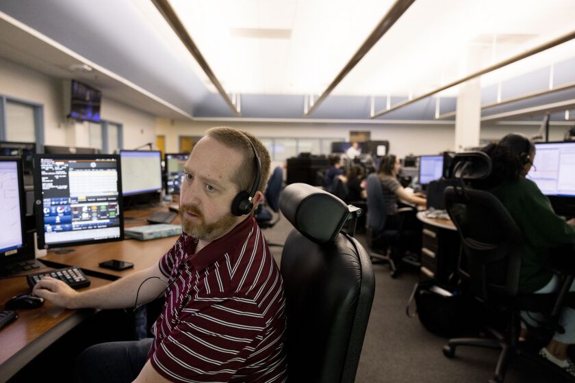 Sheriff's Emergency Services Dispatcher John J. Buie fields calls at Sheriff's Department Communications Center 