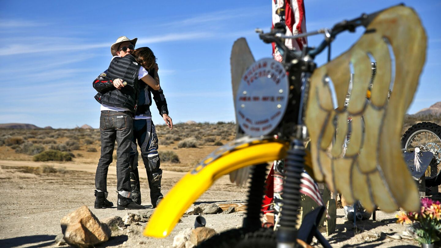 Michelle Tuchscher Marks hugs Stephen Marks after their family memorialized her late father, William Cory Tuchscher, at the Husky Monument near Randsburg, Calif.