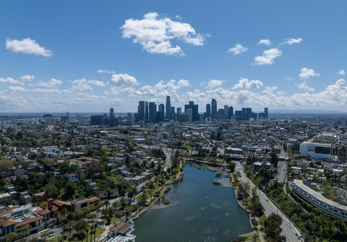 An aerial view of a city skyline with a lake in the foreground.