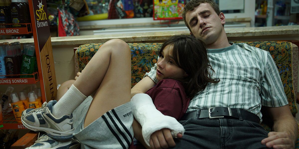 A young girl rests in the arm of a man with a cast on his arm 
