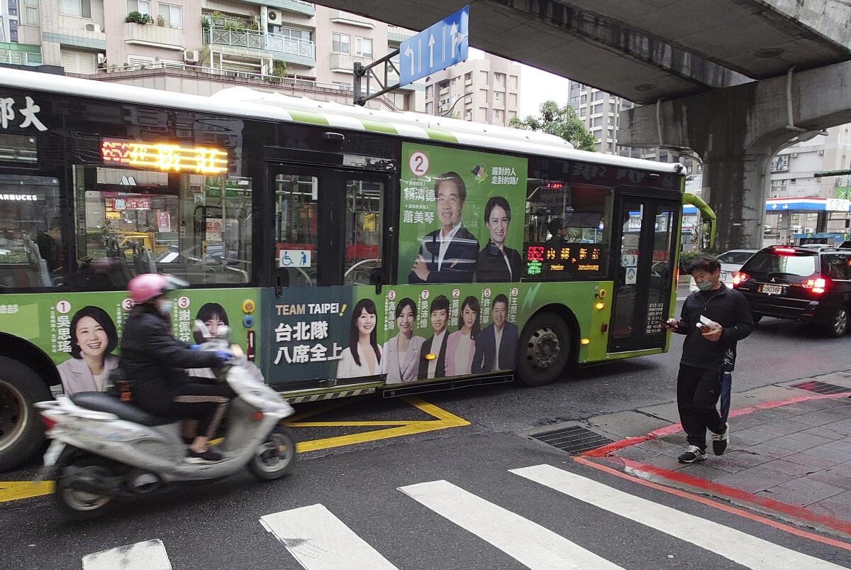 Candidates' posters of the Taiwanese presidential election are posted on a bus in Taipei, Taiwan.