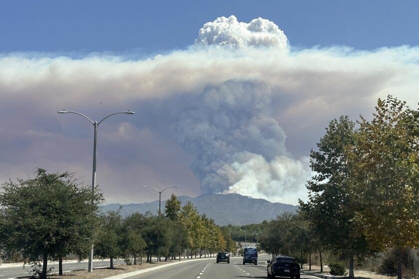 Una columna de humo generada por el incendio Airport se eleva sobre la cima de una montaña, el martes 10 de septiembre de 2024, vista desde Irvine, California (Foto AP/Eugene Garcia)