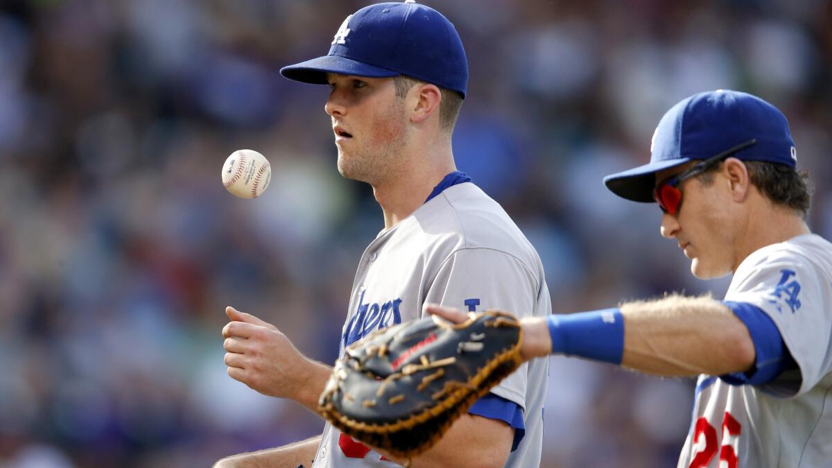 Dodgers first baseman Chase Utley pays a visit to the mound before left-hander Alex Wood is pulled from the game in the sixth inning Sunday afternoon in Denver.