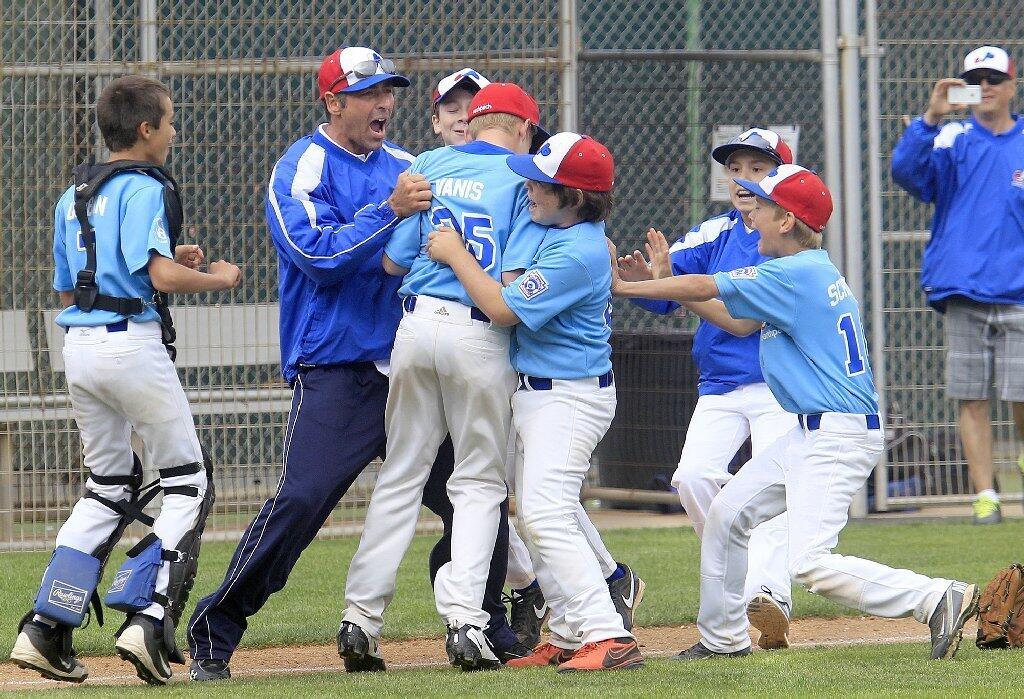 Earthpack head coach Jeff Fisher, second from left, celebrates with his players after they beat Dick's Sporting Goods in the Newport Beach Little League majors division championship game at Lincoln Elementary on Saturday.