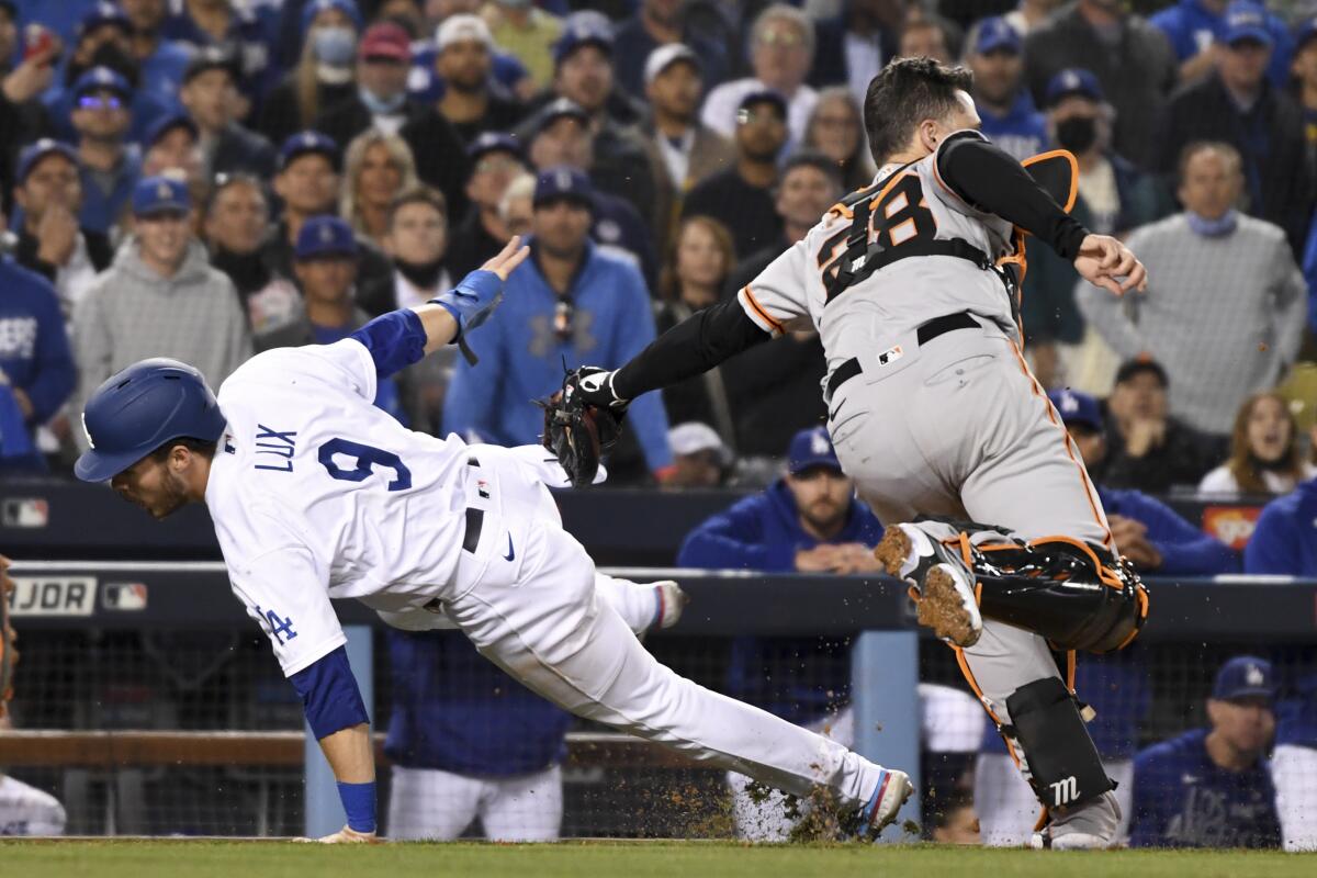 San Francisco Giants catcher Buster Posey tags out Dodgers baserunner Gavin Lux.