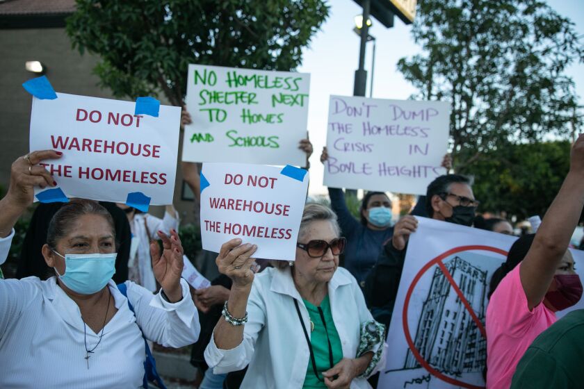 LOS ANGELES, CA - SEPTEMBER 28: Members of the East Los Angeles Boyle Heights Coalition march in protest of the revised plan to house thousands of unhoused people in the vacant Sears in Boyle Heights on Wednesday, Sept. 28, 2022 in Los Angeles, CA. (Jason Armond / Los Angeles Times)