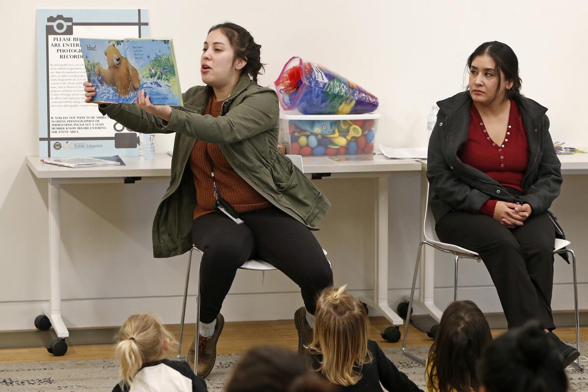 Liana Lujan, left, and Rosalba Rivera read stories in English and Spanish during Bilingual Storytime on Thursday at the Donald Dungan Library in Costa Mesa.