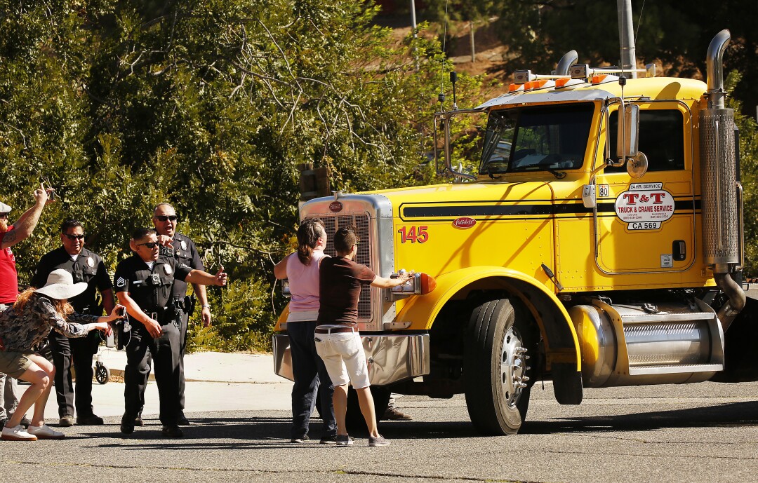 Protesters and LAPD officers confront a semitruck driver that screeched to a halt in front of a protest.