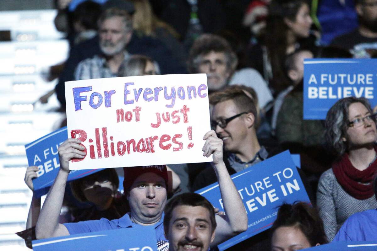 A supporter of Democratic presidential candidate Sen. Bernie Sanders holds a sign at a campaign rally in Spokane, Wash., March 24, 2016.