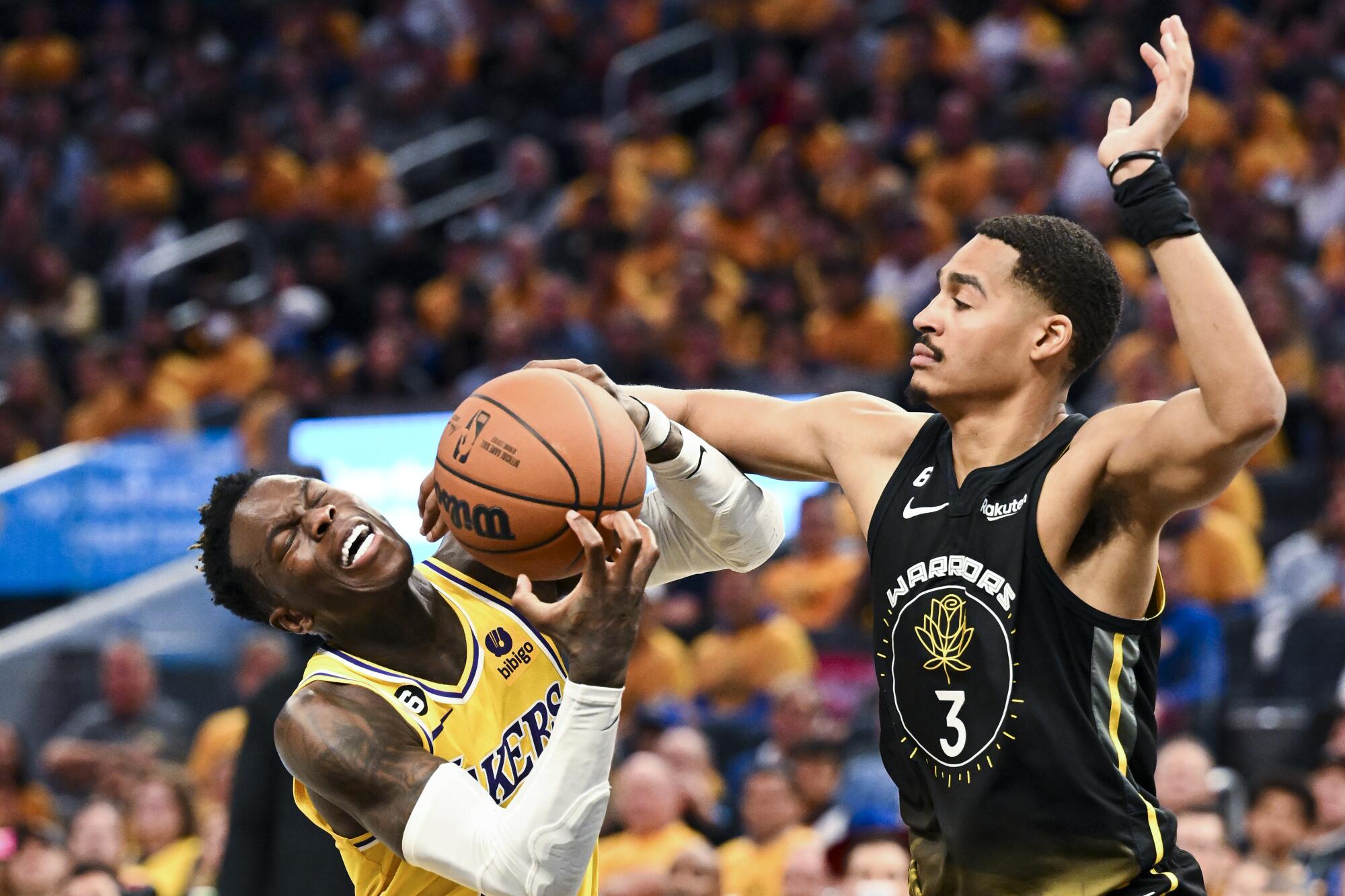 Golden State Warriors guard Jordan Poole, right, fouls Lakers guard Dennis Schroder during the second quarter.