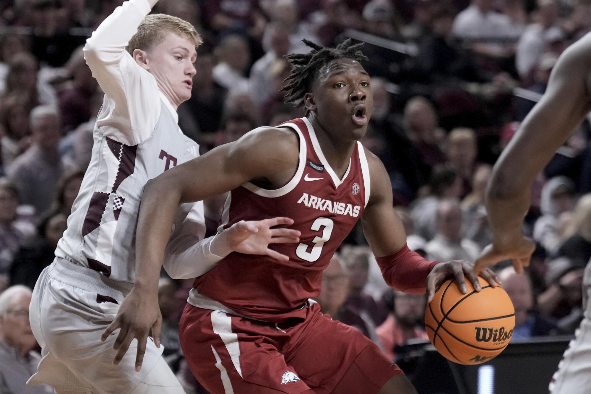Arkansas forward Adou Thiero, right, controls the ball in front of Texas A&M guard Hayden Hefner on Feb. 15.