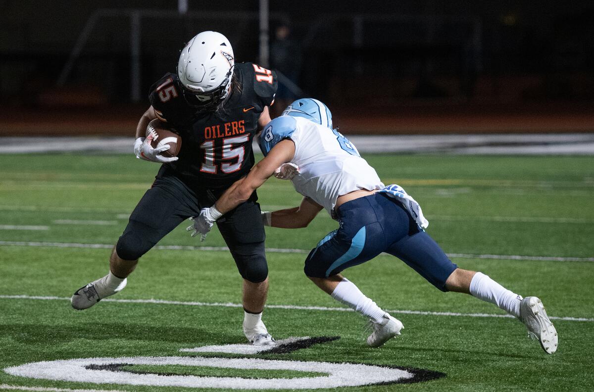 Huntington Beach’s Christian Moore breaks a tackle in a Sunset League game against Corona del Mar at Cap Sheue Field on Oct. 3.