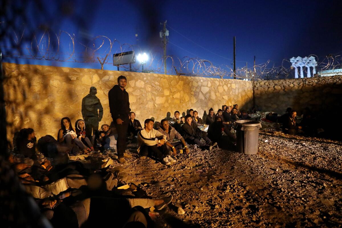 EL PASO, TEXAS -- THURSDAY, MARCH 28, 2019: Hundreds of migrants seeking asylum are held in a temporary transition area under the Paso Del Norte bridge in El Paso, Texas, on March 28, 2019. U.S. Border Patrol - Paso del Norte Port of Entry, set up the outdoor pen where some migrants, including young children and babies, have been held there for as many as four days and have been forced to sleep outside on bare gravel with only thin Mylar blankets to protect them from the cold desert nights. (Gary Coronado / Los Angeles Times)