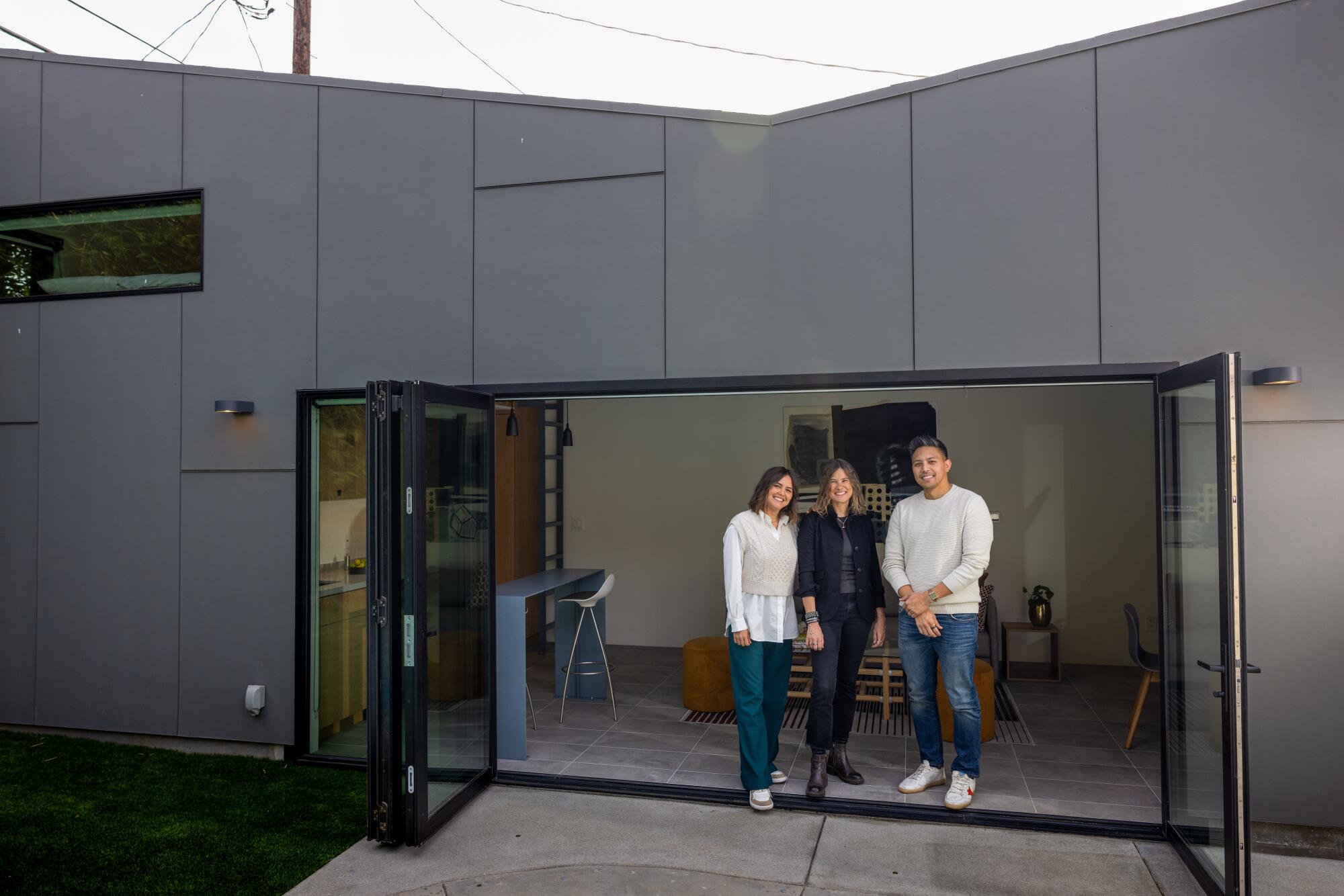 Three people stand in the doorway of an ADU.