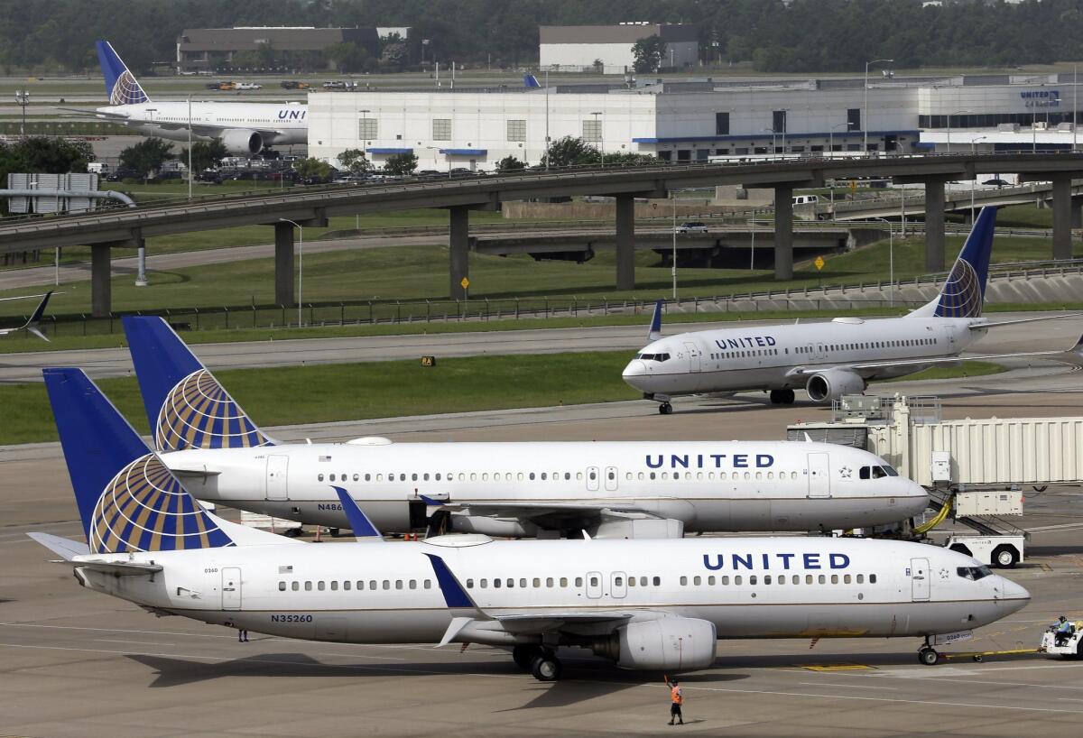 A United Airlines plane, front, is pushed back from a gate at George Bush Intercontinental Airport in Houston. Domestic airfares for the first 10 months of the year are down 5% in North America compared with the same period last year.
