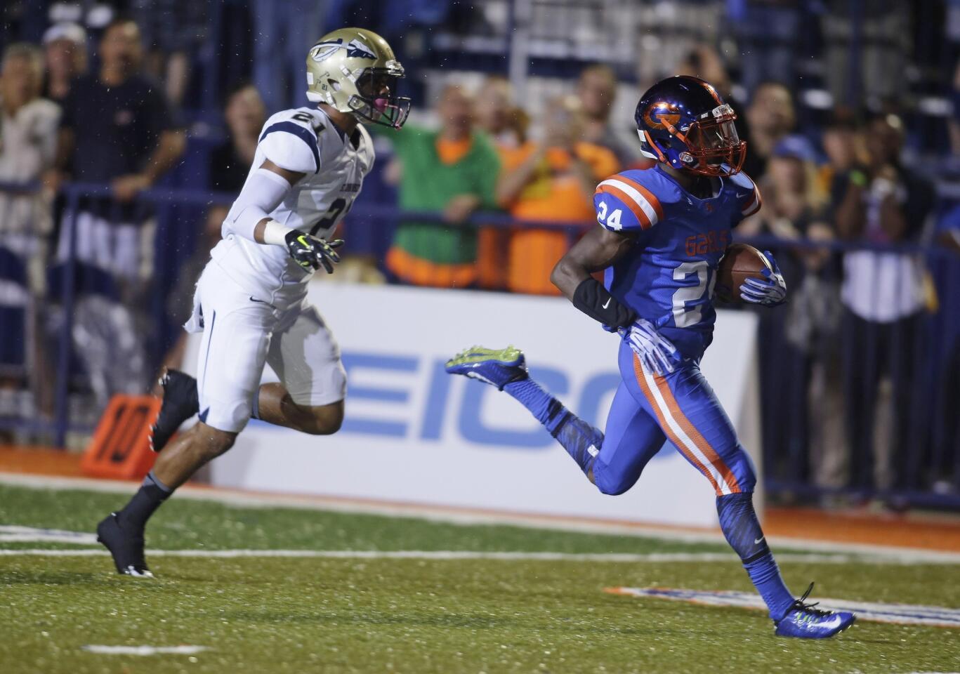 Bishop Gorman running back Russell Booze finishes off an 80-yard touchdown run against defensive back Mykal Tolliver and St. John Bosco in the first half.