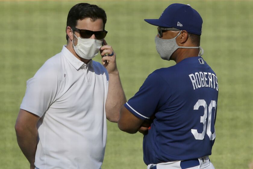 LOS ANGELES, CALIF. - JULY 3, 2020. Dodgers general manager Andrew Friedman, left, and manager Dave Roberts talk during practice at Dodger Stadium on Friday, July 3, 2020. (Luis Sinco/Los Angeles Times)