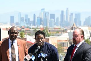 Former USC running back Reggie Bush stands next to his lawyers and speaks during a press conference at the Coliseum