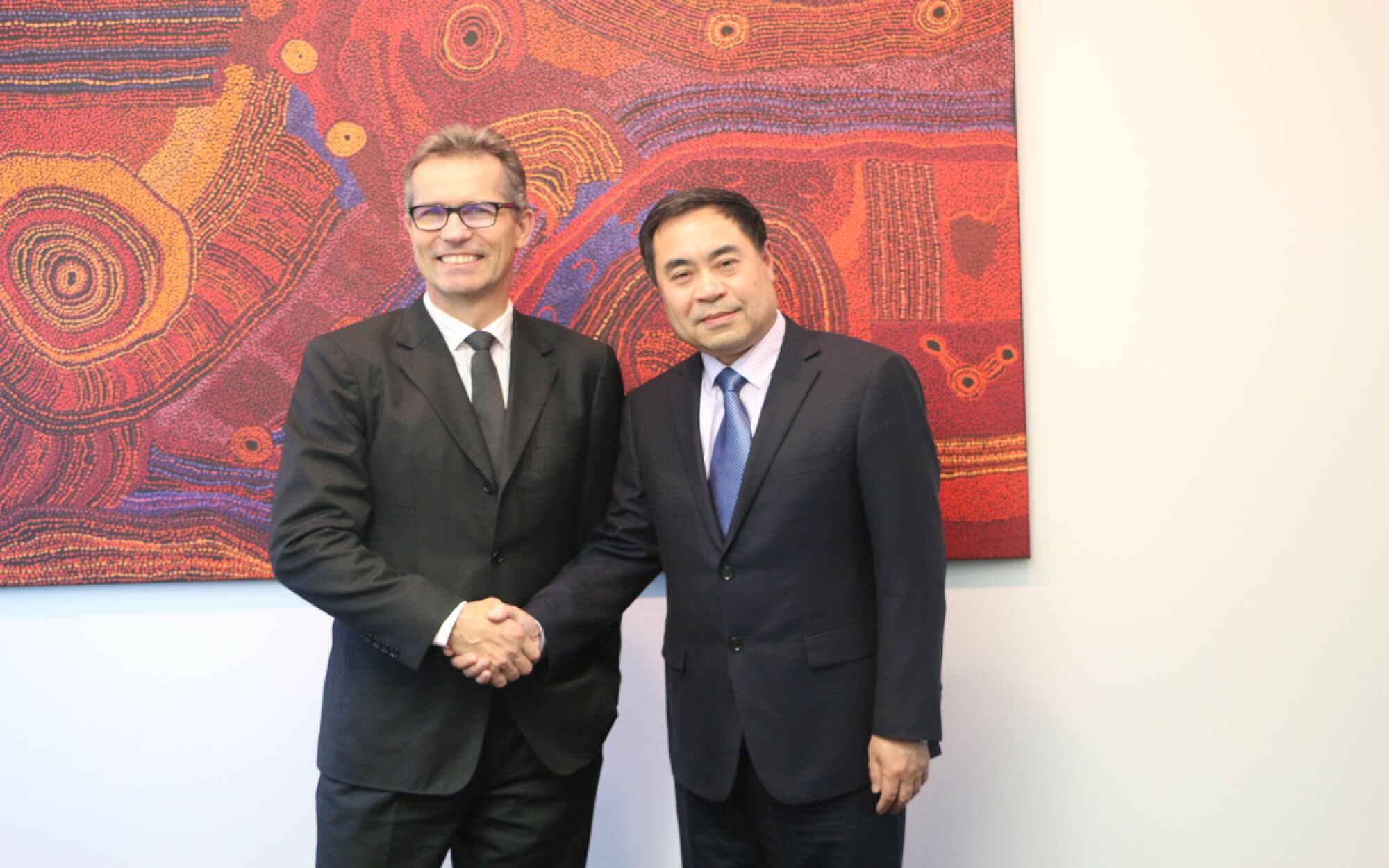 Peter Høj, vice chancellor of the University of Queensland, shakes hands with Chinese consul general Xu Jie.