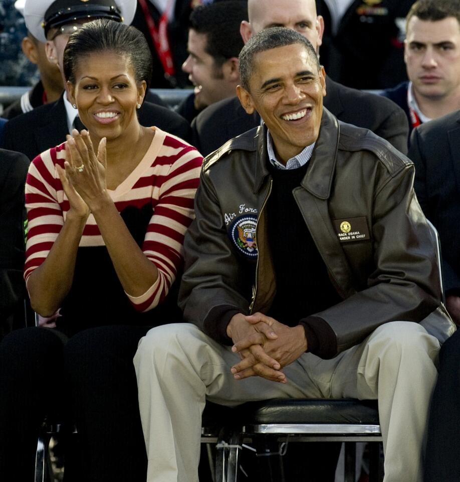 US President Barack Obama and First Lady Michelle Obama watch on the flight deck of the USS Carl Vinson during the Carrier Classic college basketball game between the University of North Carolina and Michigan State University in San Diego, California, November 11, 2011.