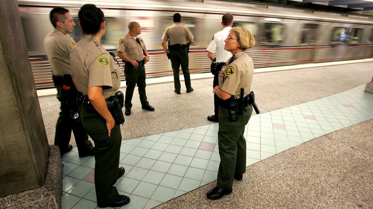 Sheriff's deputies guard the Hollywood/Highland Red Line station platform. A bundle of contracts approved Thursday will shift the bulk of Metro's policing duties from the Sheriff's Department to police departments in Los Angeles and Long Beach.
