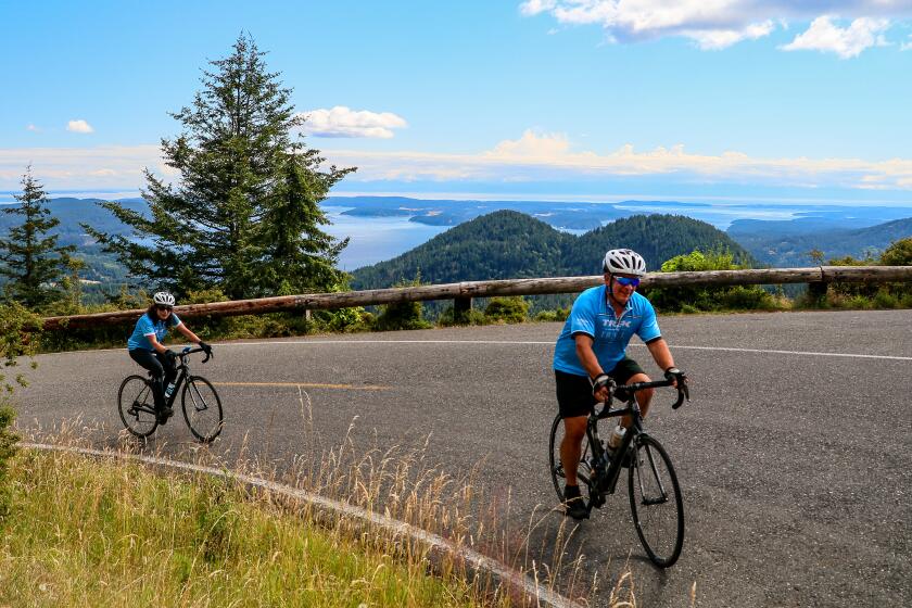 A couple climbs a hill overlooking the Washington's coastal islands.