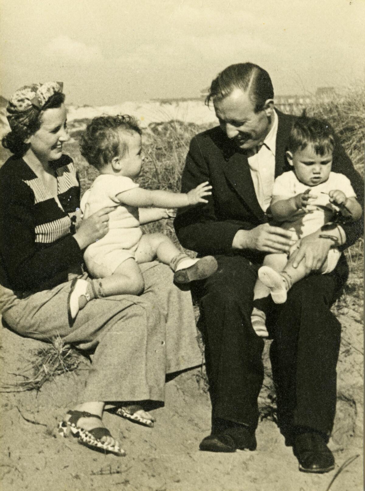 A black-and-white photo of a couple and their two small children.