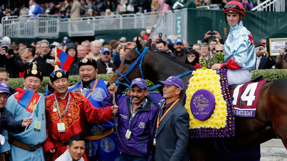 Mongolian Saturday, with Florent Geroux aboard, poses in the Winner's Circle at Keeneland Racecourse with its owners and trainer Saturday.