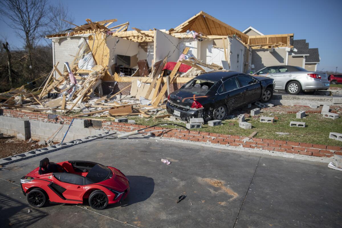 A child's toy car sits near damaged cars and homes in Bowling Green, Ky., after a tornado.