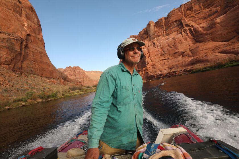 Colorado River, below Glen Canyon Dam-July 1, 2022-John Weisheit glides up the still waters just below Glen Canyon Dam. worked as a Colorado River guide for 21 years before becoming the Colorado Riverkeeper in 2002. Weisheit pushes a raft into the river just west of Moab, Utah before embarking on a river trip on June 26, 2022. (Carolyn Cole / Los Angeles Times)
